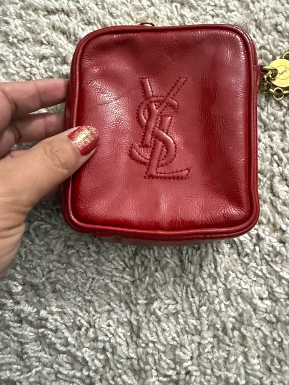 red Yves Saint Laurent Belle de Jour patent leather wristlet pouch.